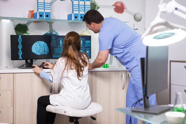 Jonge scheikundige man werkzaam in een laboratorium met een vrouwelijke microbioloog — Stockfoto