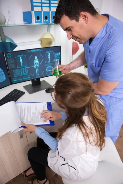 Jeune homme scientifique travaillant avec une microbiologiste dans un laboratoire de recherche — Photo