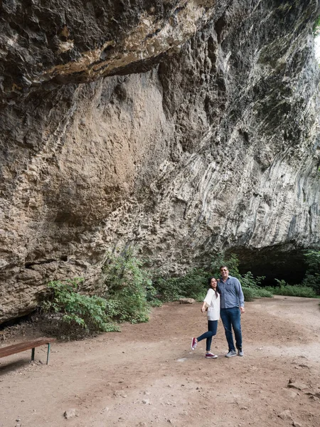 Hermosa pareja joven explorando una cueva en las montañas — Foto de Stock