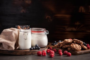 Rustik ahşap masa üzerinde koyu çikolata ve yaban mersini ile lezzetli kurabiye
