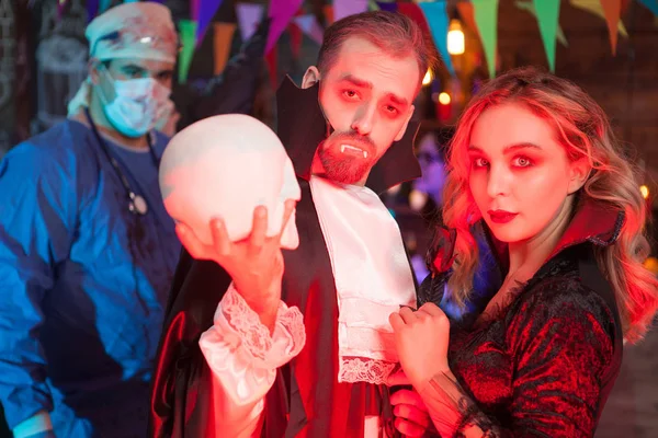 Attraente giovane uomo vestito come Dracula con la sua bella ragazza per la festa di Halloween — Foto Stock