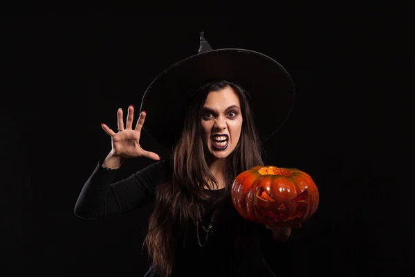 Готична молода жінка в костюмі відьми Хелловін стоїть над чорним тлом — стокове фото