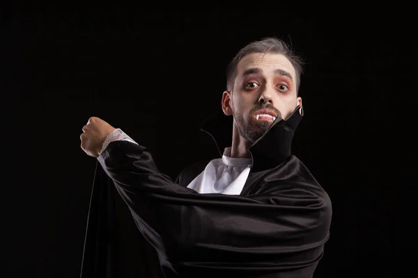 Überraschter junger Mann im Dracula-Kostüm mit großen Augen — Stockfoto