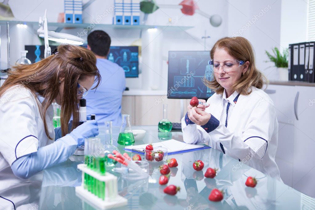 Middle age female in white coat working as scientist in a lab research