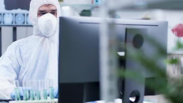 Retrato de un científico masculino con monos blancos trabajando en el PC — Vídeos de Stock