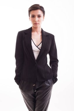 Beyaz arka plan üzerinden kameraya bakan deri pantolon ile Büyüleyici genç kadın