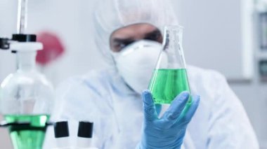 Biyoteknoloji uzmanı yeşil sıvı ile bir örnek bakıyor