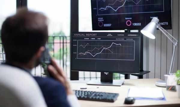 Achteraanzicht van Young Business man met een serieuze conversatie op zijn mobiele telefoon in zijn kantoor — Stockfoto