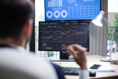 İş adamı tarafından profesyonel analiz için bilgisayar monitöründe görüntülenen grafikler