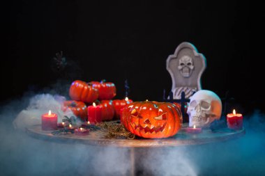 Korkunç kabak ve ürpertici kafatası cadılar bayramı partisinde ahşap bir masada birlikte oturan