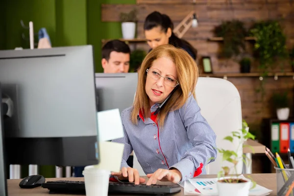 심각한 백인 비즈니스 여자 작업 에서 그녀의 컴퓨터 과 데 a 전화 — 스톡 사진