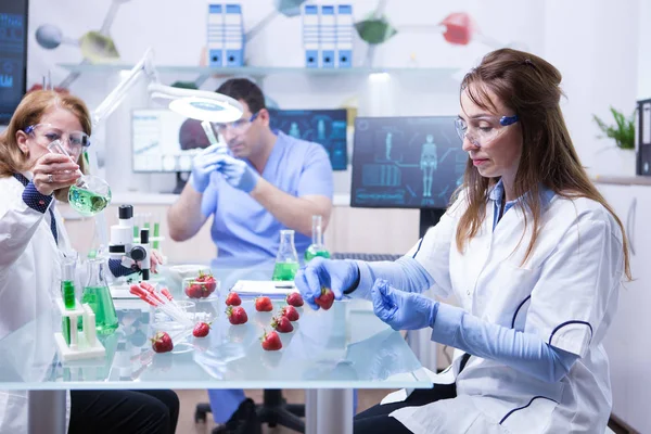 Científica de mediana edad usando guantes de protección en un laboratorio de investigación — Foto de Stock