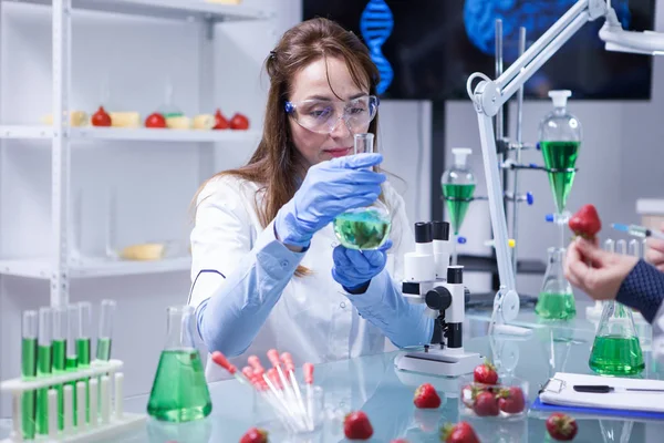 Femme scientifique d'âge moyen portant des lunettes de protection dans un laboratoire de recherche — Photo