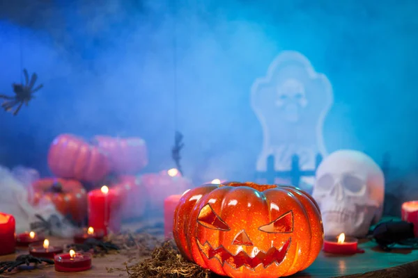 Scary pumpkin for halloween surrounded by mist on a wooden table