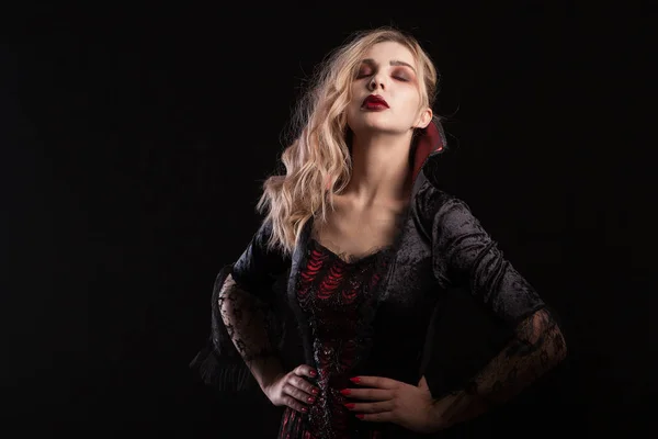 Mujer vestida como un vampiro posando para el carnaval de Halloween sobre fondo oscuro —  Fotos de Stock