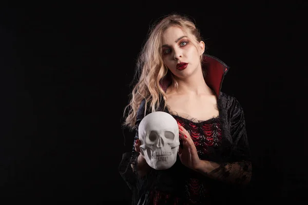 Human skeleton holded by beautiful woman dressed up like a sexy vampire for halloween — Stock Photo, Image