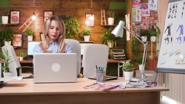 Hermosa mujer rubia trabajando en su ordenador en un lugar de trabajo creativo profesional — Vídeos de Stock