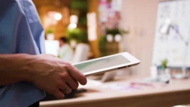 Kadın iş sahibi bir tablet tutan ve onu yaratıcı ofisinde yazarak