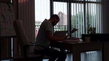 Ofisinde önemli bir proje üzerinde çalışan yaratıcı yönetmen silueti