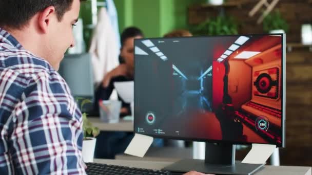 Wesoły młody biznesmen przerwę od pracy, aby grać w gry wideo na swoim komputerze — Wideo stockowe