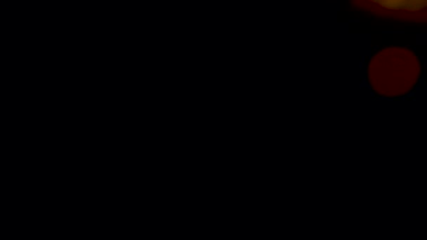 黒い背景に暖かいオレンジ色のレンズフレア — ストック動画