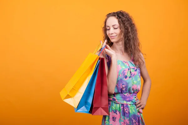 Şık elbiseli şık kadın alışveriş poşetlerini aşağı yaslar — Stok fotoğraf