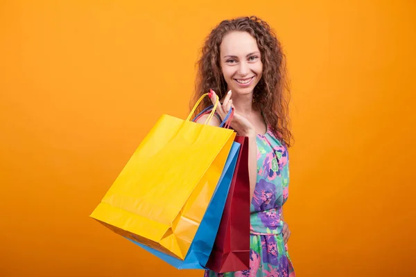 Şık beyaz kadın gülümseyen ve alışveriş çantaları tutan — Stok fotoğraf