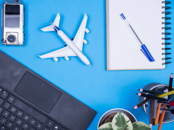 Flat lay top view of modern traveler over blue background. Modern gadgets.