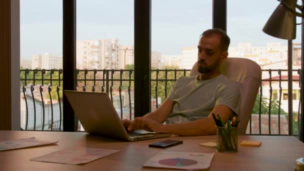 Managerul lucrează târziu într-un birou luminat de lumina caldă a soarelui — Videoclip de stoc