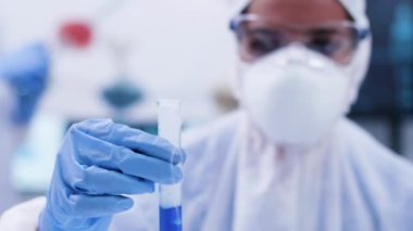 Sigara mavi fuid ile bir test tüpü tutan kimyager araştırmacı yakın