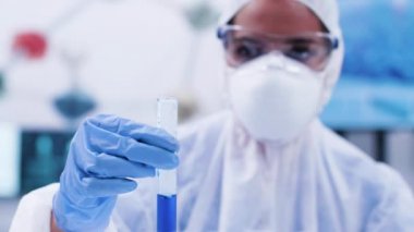 Kadın bilim adamı görünümlü ve bir test tüpü nde sigara mavi sıvı tutan