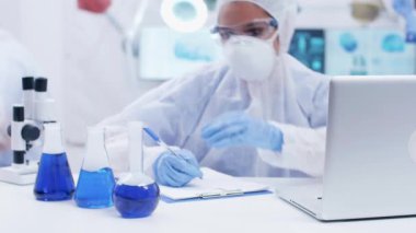 Kimya laboratuvarında farklı sigara mavi sıvıları ile çalışan kadın bilim adamı