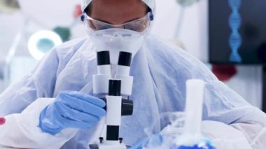 Kimyager bilim adamı modern bir mikroskop kullanarak laboratuvar araştırması yapıyor