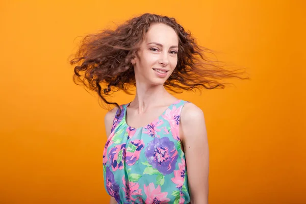 Веселая молодая женщина трясет своими великолепными волосами в студии — стоковое фото