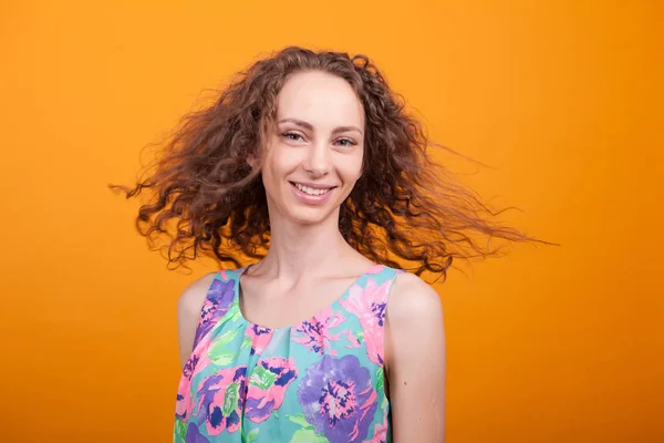Krásná ženská portrét s úsměvem a potřásaje si kudrnatými vlasy — Stock fotografie