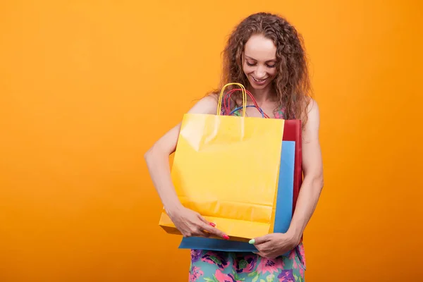 Gorgeous kvinna leende och tittar ner på hennes färgglada shoppingväskor — Stockfoto