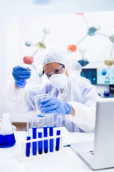 Junger Forscher mit Pipette und Glasgefäß in der Hand — Stockfoto