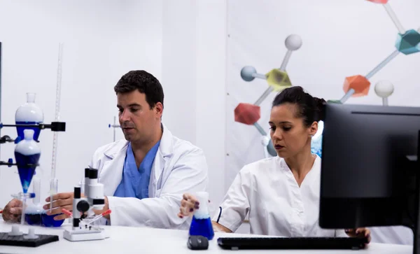 Команда дослідників, які носять пальто в сучасній дослідницькій лабораторії — стокове фото