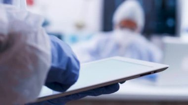 Tabletüzerinde formül yazarak modern bir laboratuvarda çalışan kimya bilim adamı