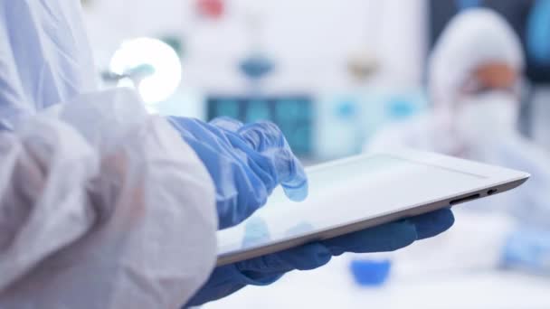 Uzavřít kapesní záběry chemika napsaný na tabletu v výzkumné laboratoři — Stock video