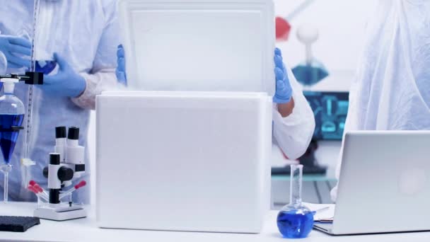 Equipe de cientistas químicos abrindo uma caixa de geladeira em um laboratório de pesquisa moderno — Vídeo de Stock