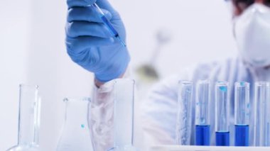 Reaktif mavi sıvı içinde pipet ile çözelti dökme kimyager el görüntüleri kapatın