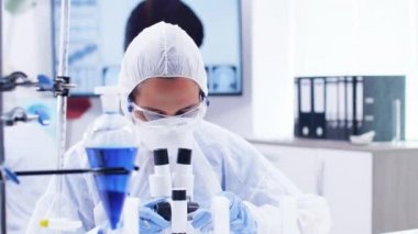 Modern laboratuvarda mikroskobu ayarlayan tüm ekipmanlarda kadın bilim adamı