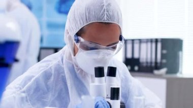 Araştırma laboratuvarında moden mikroskobundan bakan kadın bilim adamının yakın çekim görüntüleri