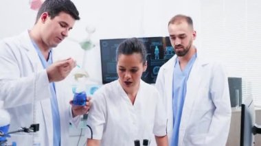 Modern laboratuvarda kimyagerler mavi sigara sıvı ile çalışan