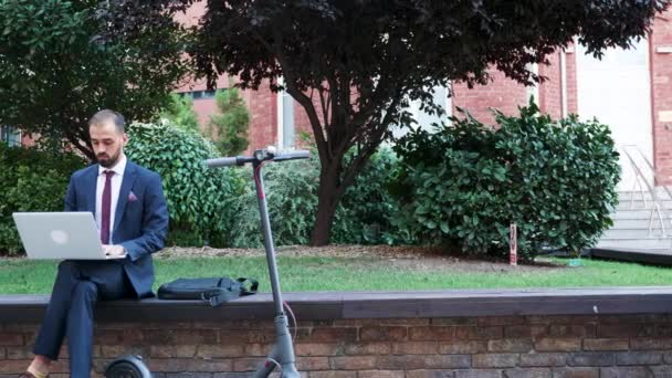 Jeune travailleur tapant sur l'ordinateur portable à l'extérieur de son bureau — Video