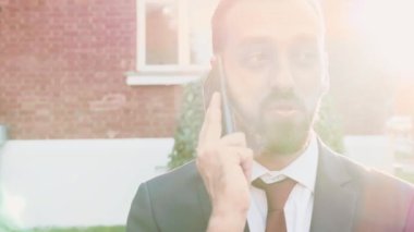 Yönetici telefonda bir konuşma yapıyor, şehirde açık havada