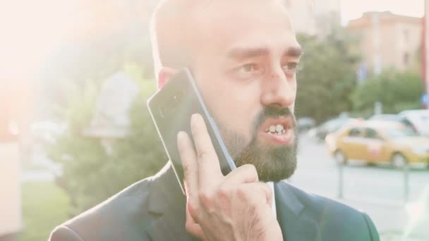 Portrét hezkého obchodníka, který mluví po telefonu, zatímco světlice se rozptyloví na obrazovce — Stock video