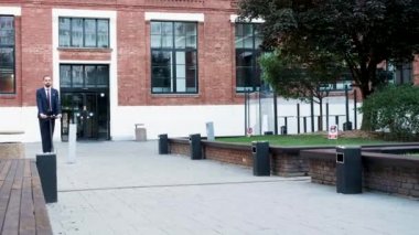 İş bölgesinde elektrikli scooter kullanan işadamı