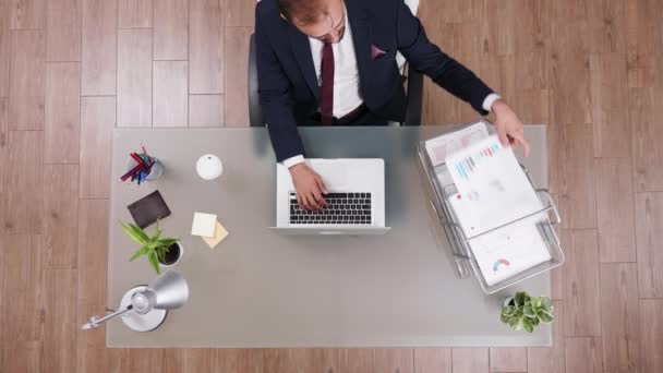 Top view hombre de negocios escribiendo y leyendo datos de un gráfico — Vídeos de Stock